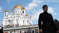File Photo of Russian Orthodox Cathedral in Moscow, with Man in Religious Garb in Foregraound and Crowd Milling About in Background