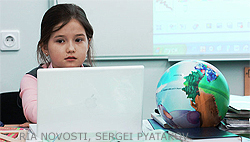 File Photo of Little Russian Girl at Computer Next to Globe