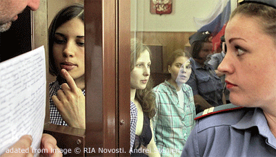 Pussy Riot Defendants In Courtroom Enclosure, With Man Showing One Papers While Female Guard Looks On