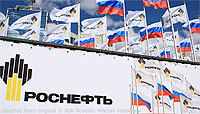 File Photo of Rosneft Logo on Wall Beneath Array of Rosneft and Russian Flags