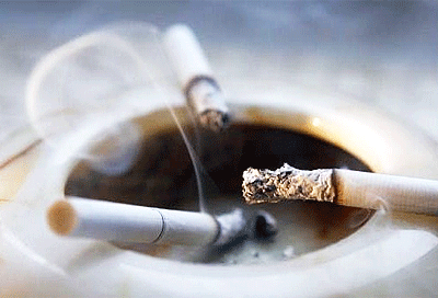 Image of Ashtray with Smoldering Cigarettes and Curl of Smoke
